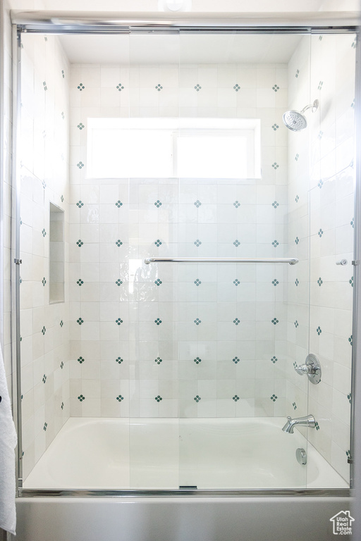 Bathroom with bath / shower combo with glass door and plenty of natural light