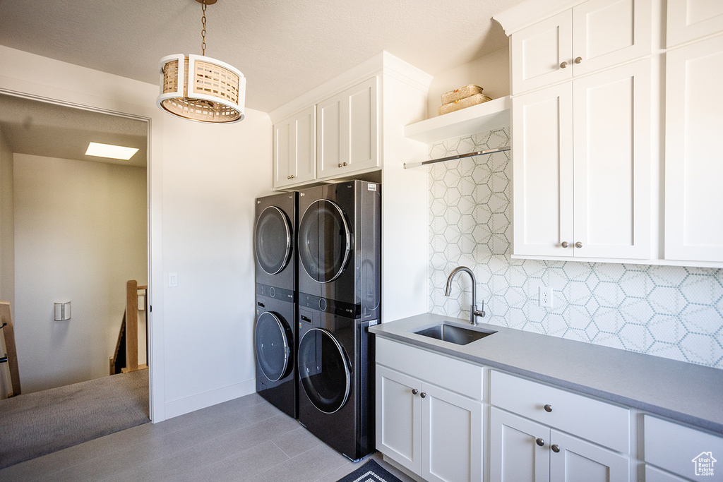 Laundry area featuring cabinet space and stacked washer and clothes dryer