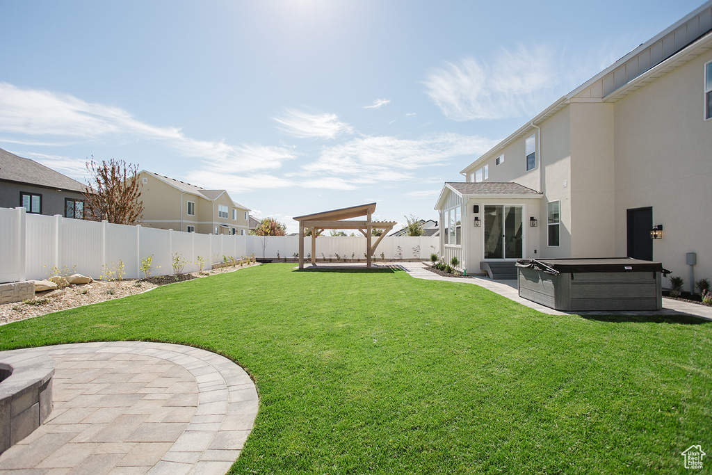View of yard with a hot tub and a patio area