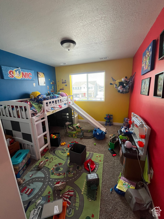 Carpeted bedroom featuring a textured ceiling