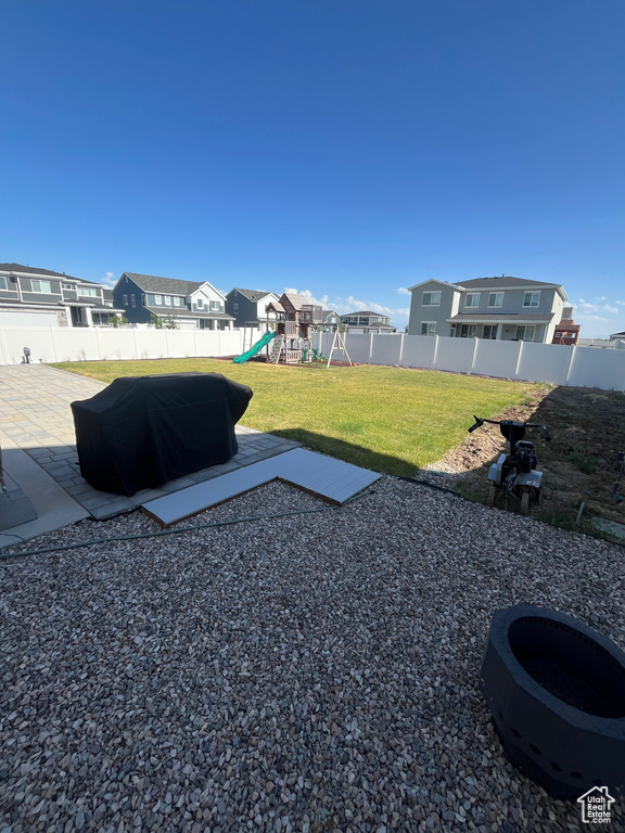 View of yard with a playground, a patio, and a residential view