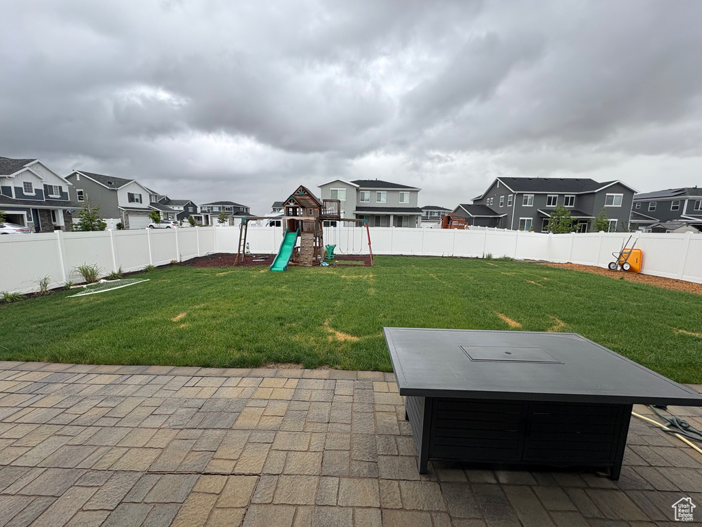 View of patio / terrace with a playground, a residential view, and a hot tub