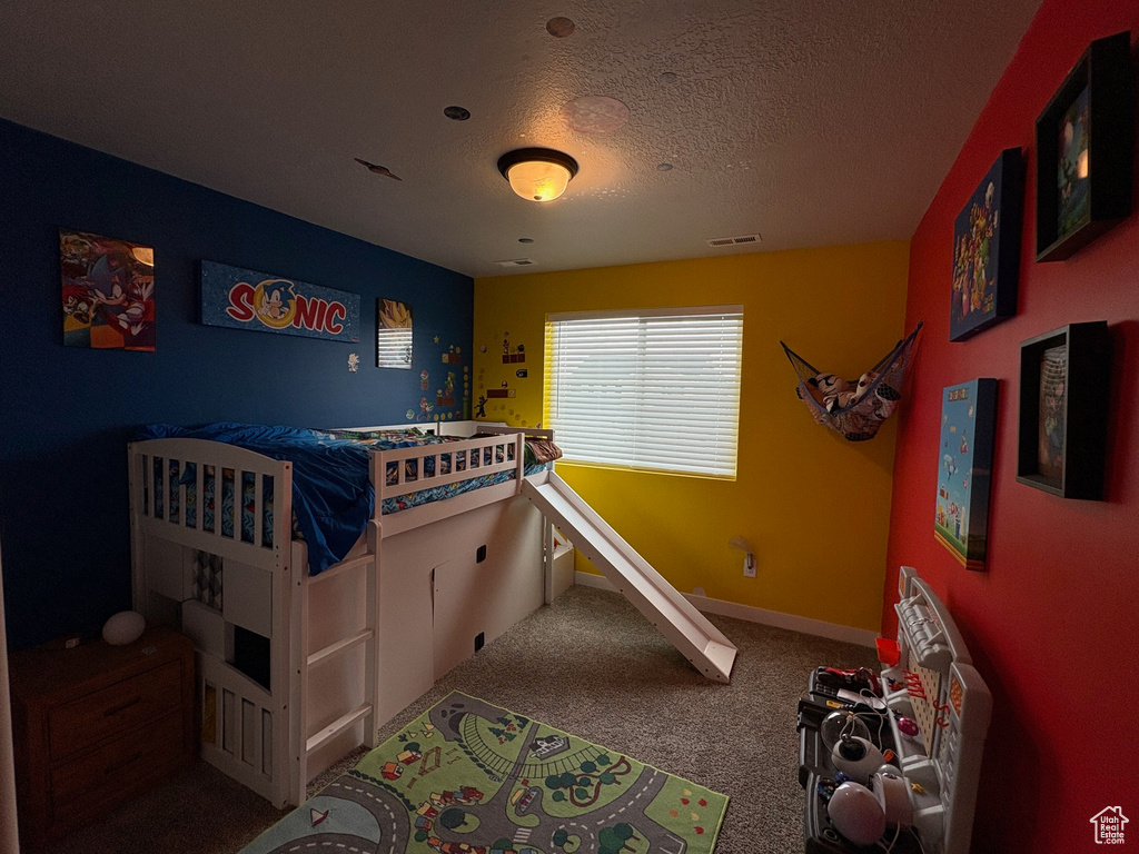 Bedroom featuring carpet floors, a textured ceiling, and baseboards