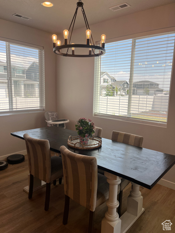 Dining area with a chandelier, wood finished floors, baseboards, and recessed lighting