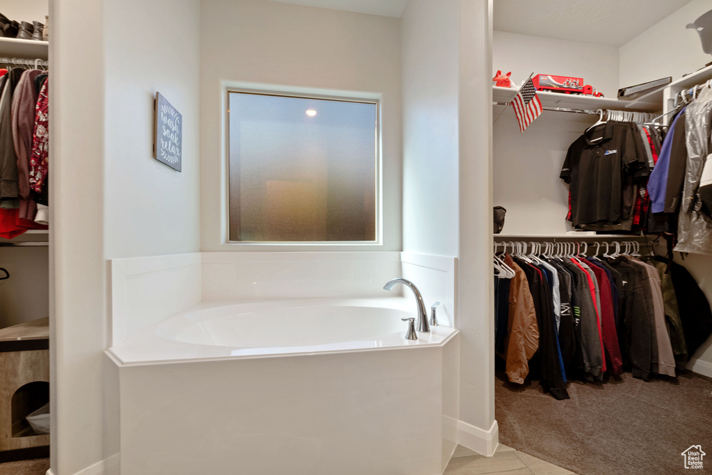 Full bathroom with a garden tub and a walk in closet