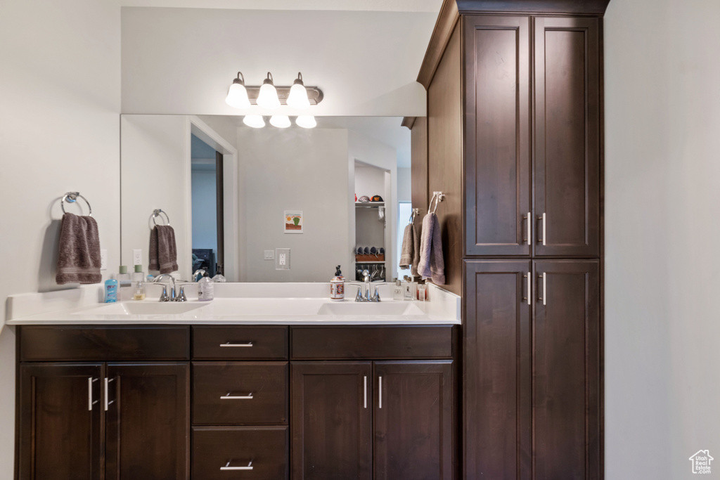 Full bathroom with double vanity and a closet