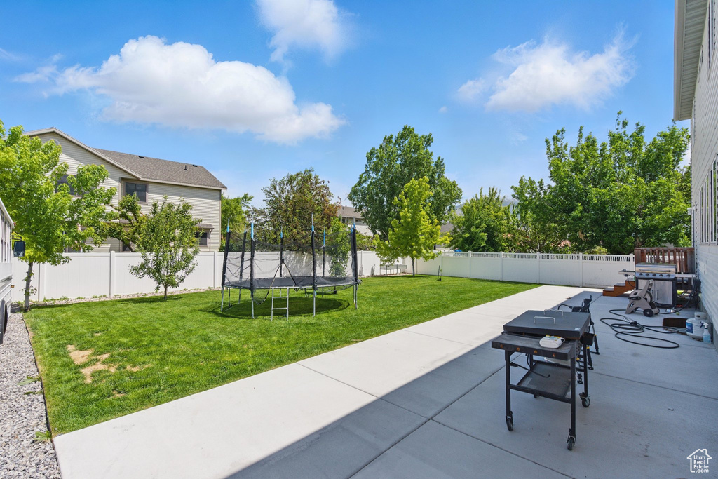 View of patio featuring a trampoline and area for grilling