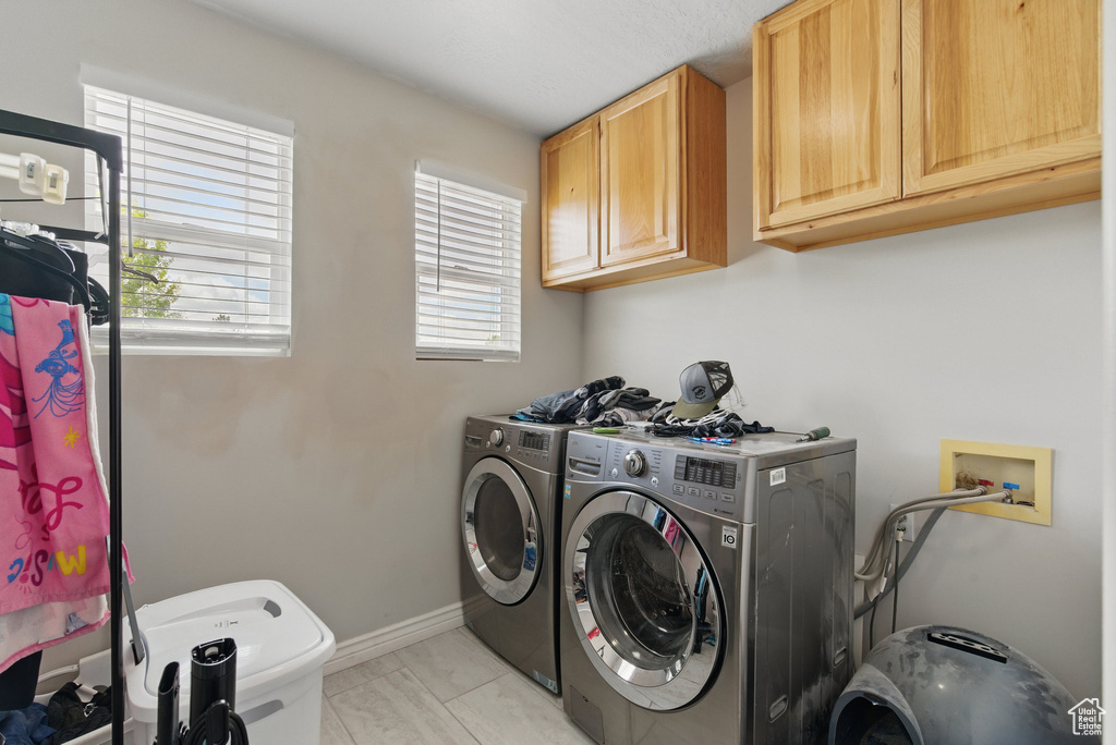 Laundry room featuring cabinet space, washing machine and clothes dryer, and baseboards