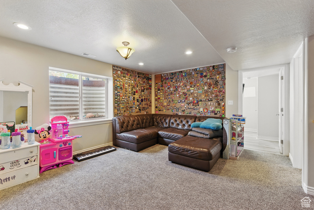 Living area with a textured ceiling, carpet floors, recessed lighting, and baseboards