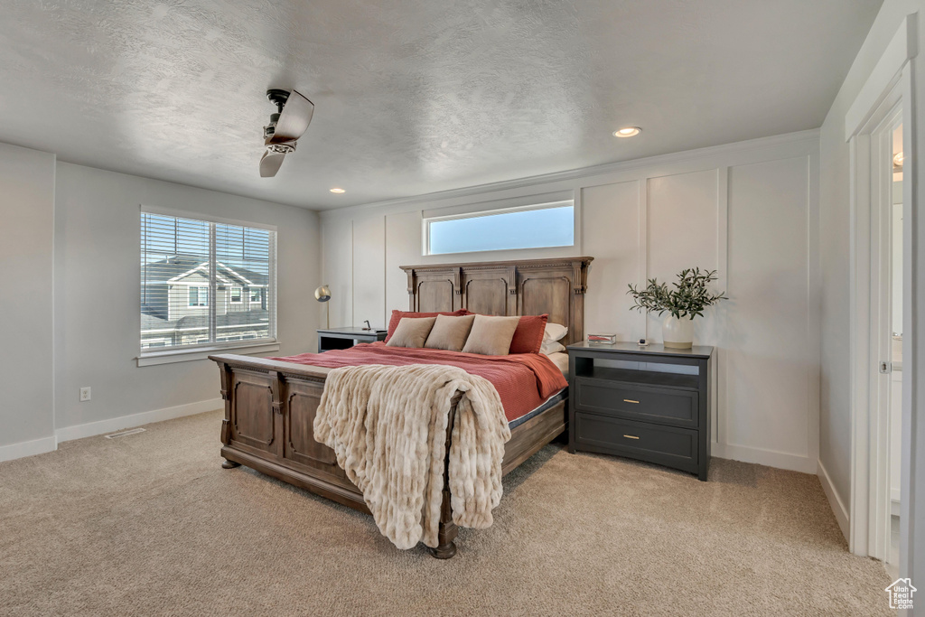 Bedroom featuring baseboards, light colored carpet, recessed lighting, a ceiling fan, and a textured ceiling