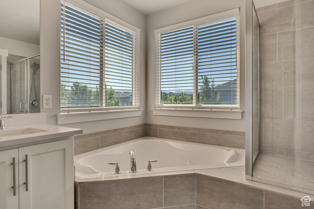 Full bath featuring vanity, a shower stall, and a garden tub