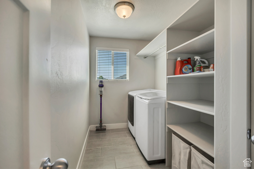 Washroom with separate washer and dryer, baseboards, and light tile patterned flooring