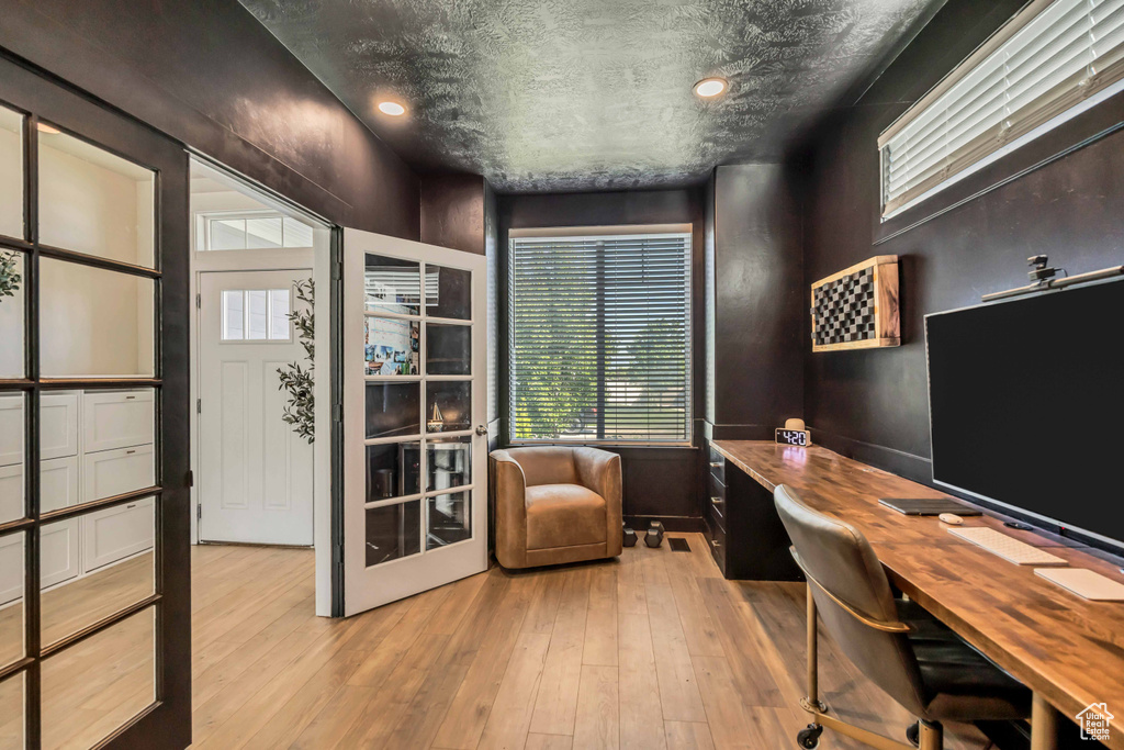 Home office featuring light wood finished floors and healthy amount of natural light