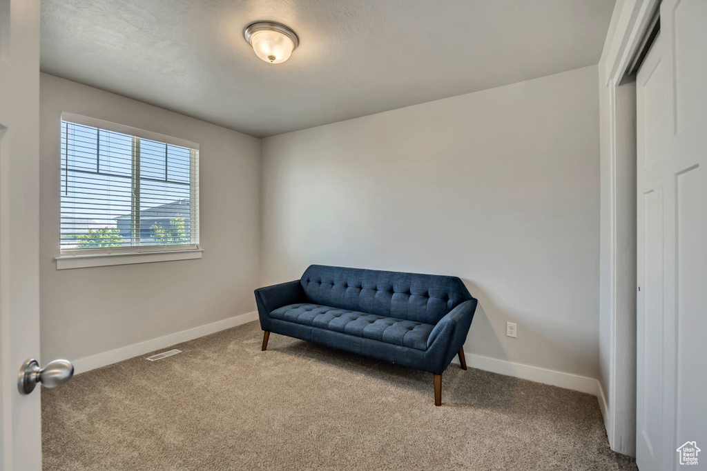 Sitting room featuring carpet flooring and baseboards