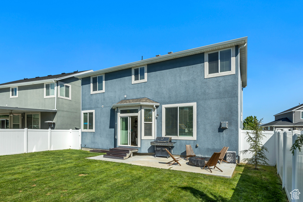 Back of house featuring stucco siding, a patio, and a fire pit