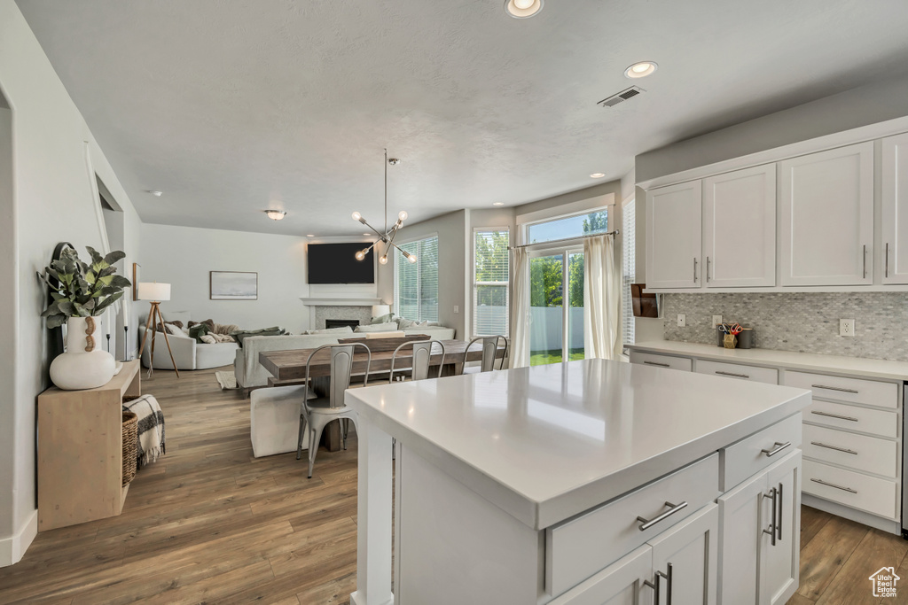 Kitchen with open floor plan, white cabinetry, backsplash, dark wood-style floors, and recessed lighting
