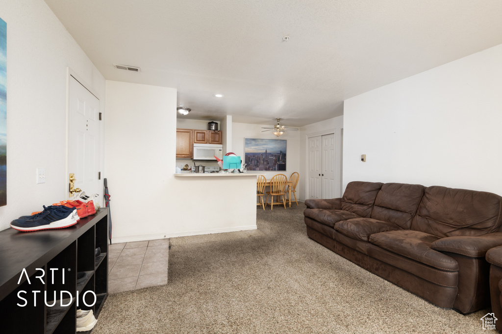 Living area featuring carpet floors, ceiling fan, and recessed lighting