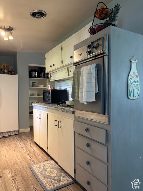 Kitchen with fridge and light wood finished floors