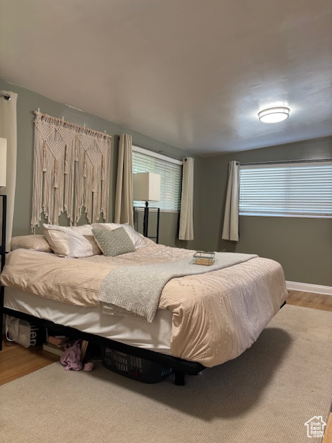 Bedroom with wood finished floors and baseboards