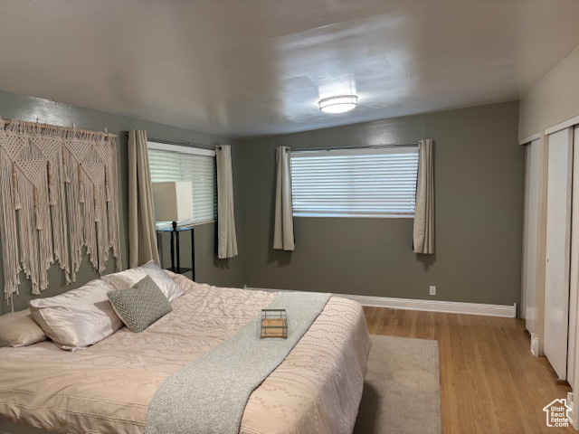 Bedroom with wood finished floors and baseboards