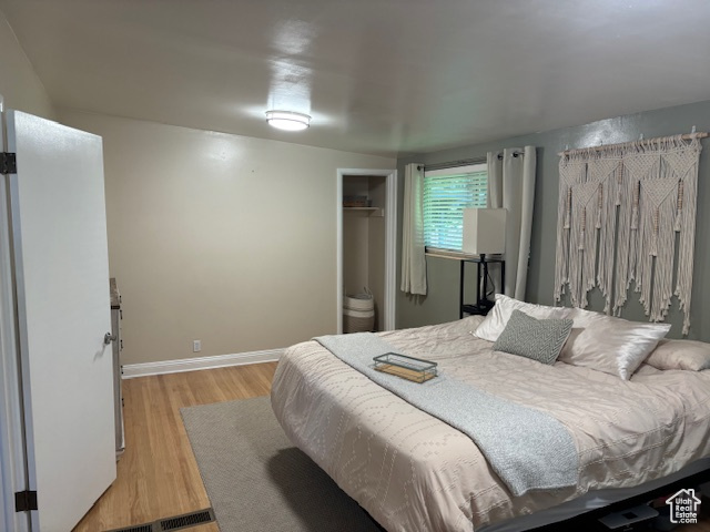 Bedroom with light wood-type flooring, a closet, and baseboards