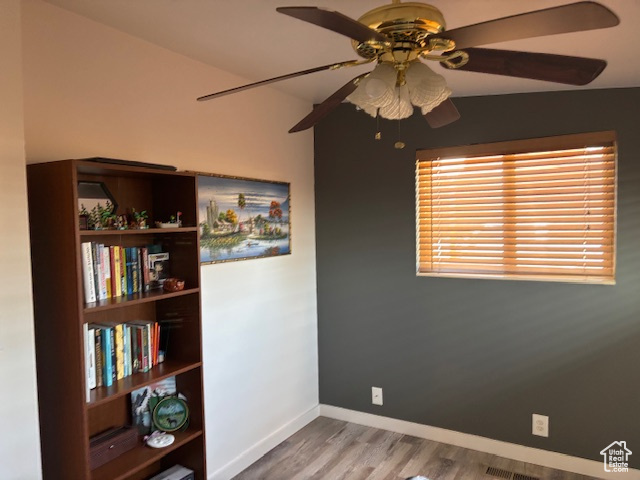 Spare room with ceiling fan, baseboards, and wood finished floors