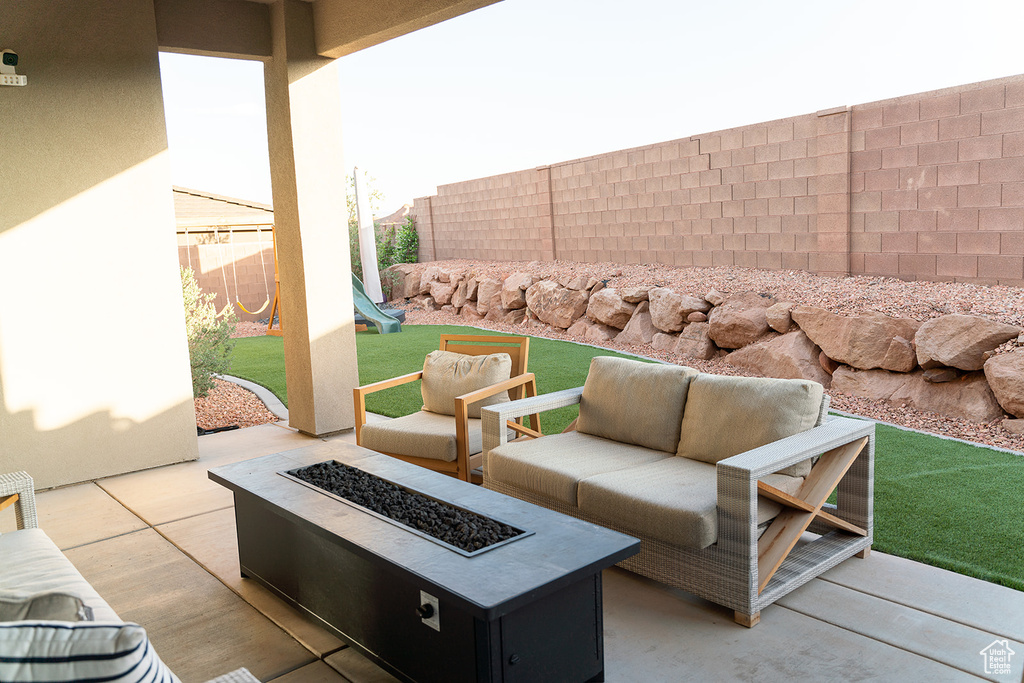 Fenced backyard with a patio, an outdoor living space with a fire pit, and a playground
