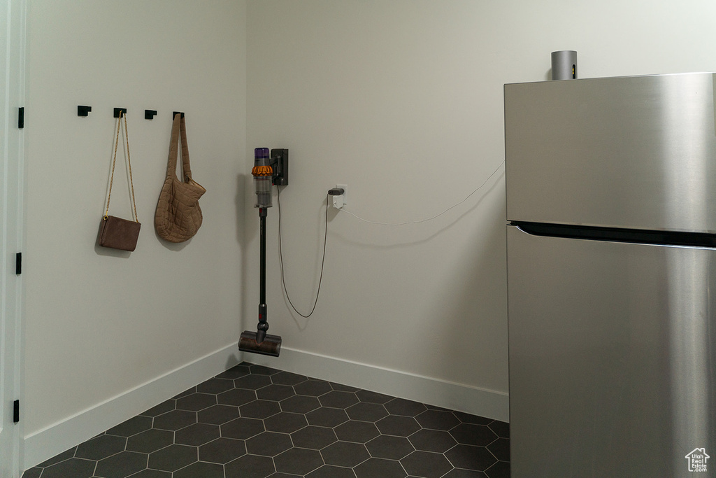 Laundry area with dark tile patterned floors and baseboards