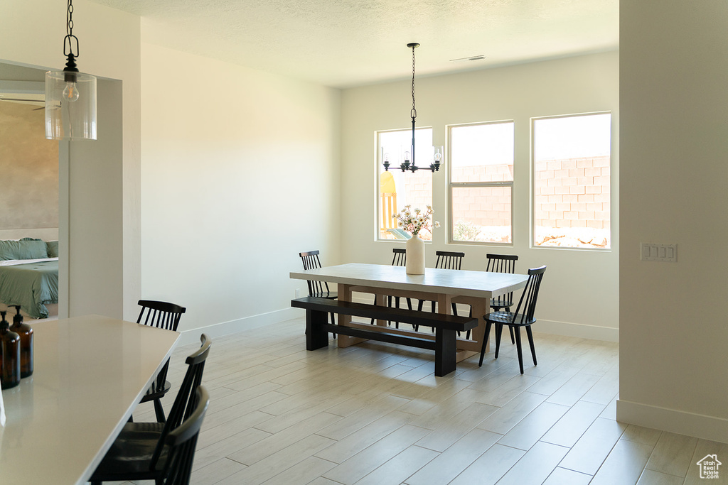 Dining space featuring baseboards, a chandelier, and light wood-type flooring