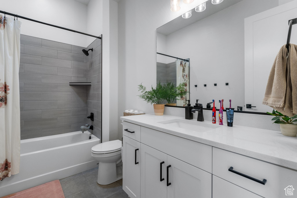 Bathroom featuring vanity, tile patterned floors, shower / tub combo with curtain, and toilet