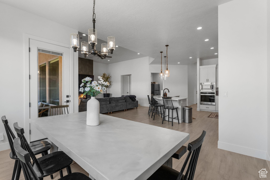 Dining room featuring a chandelier, recessed lighting, light wood-style floors, and baseboards