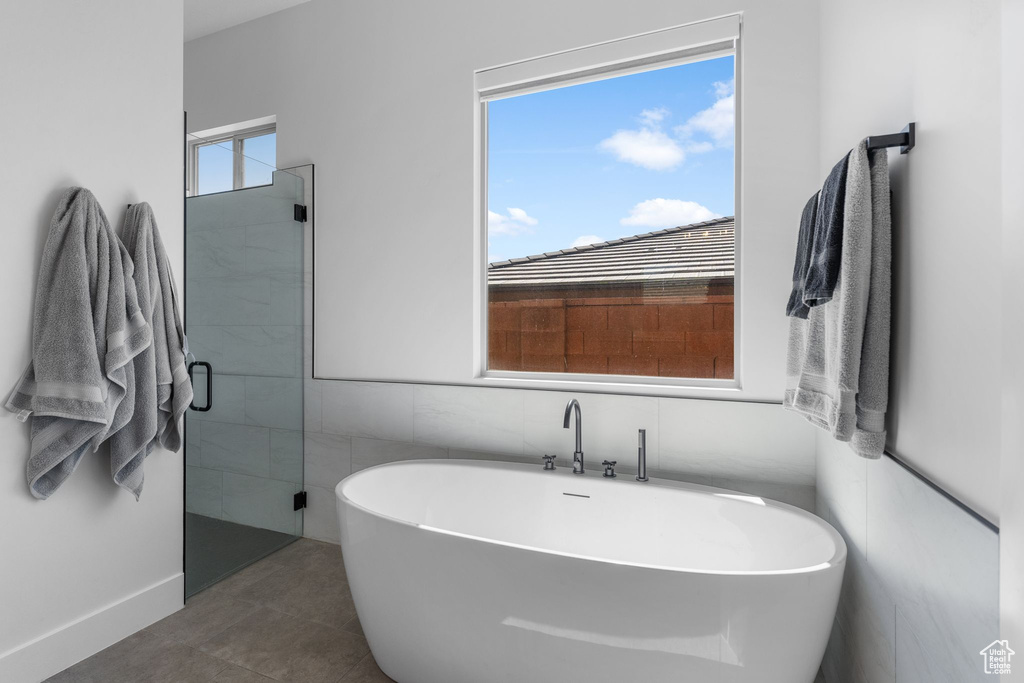 Bathroom featuring a freestanding tub, a shower stall, and tile patterned flooring