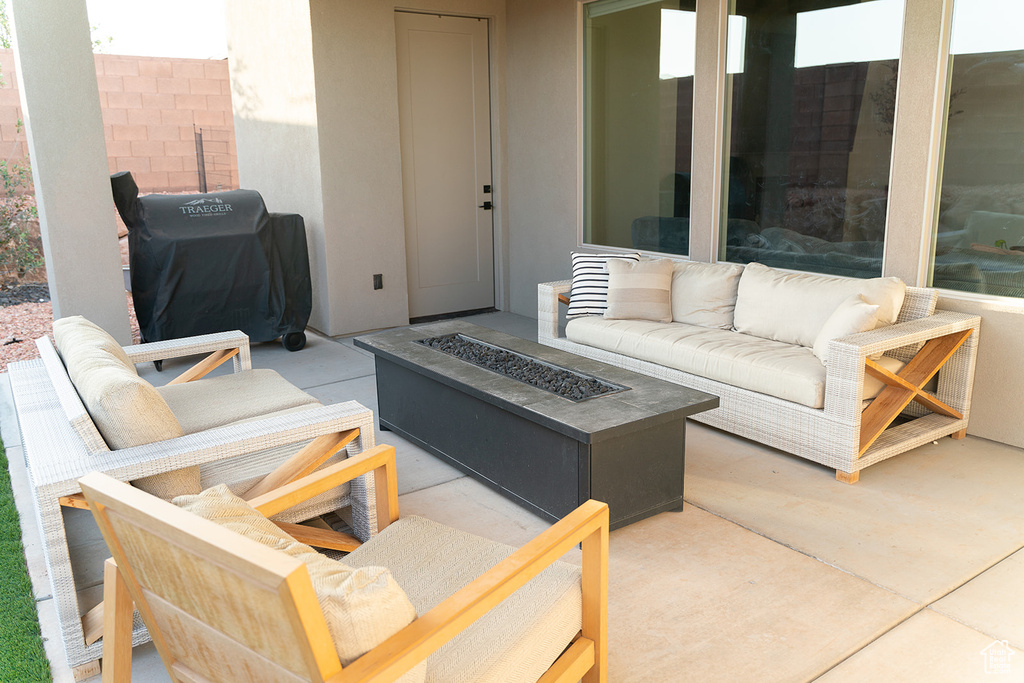 View of patio featuring grilling area and an outdoor living space with a fire pit