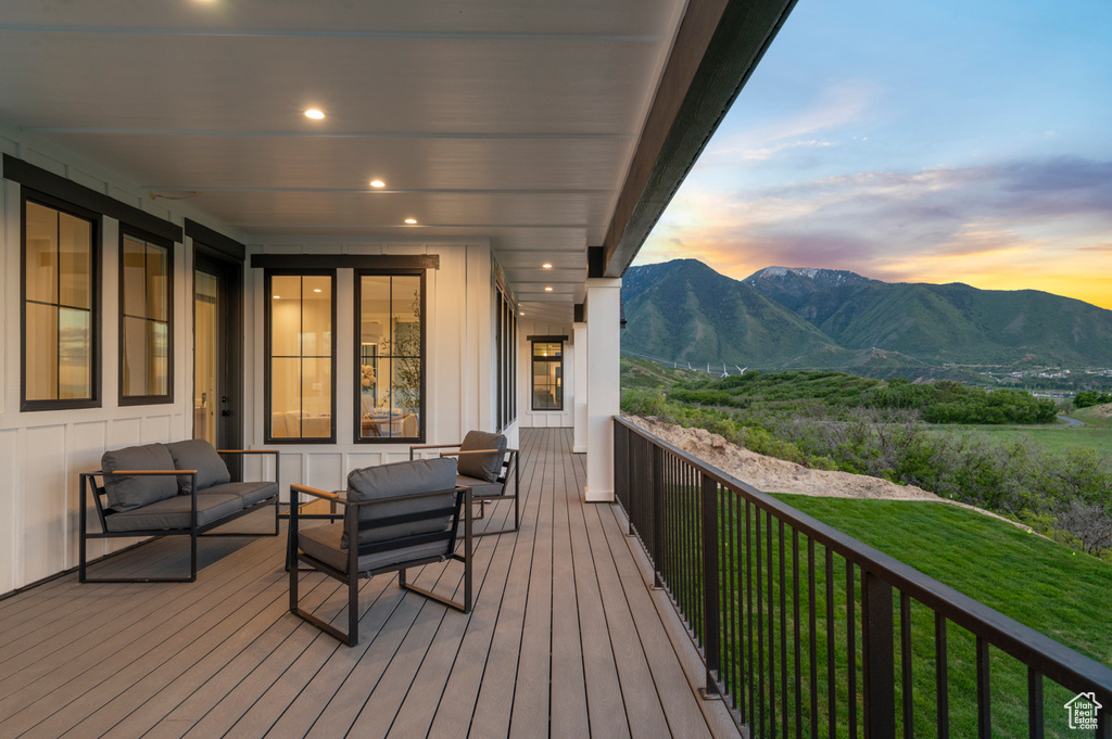 Deck at dusk featuring a mountain view and an outdoor hangout area
