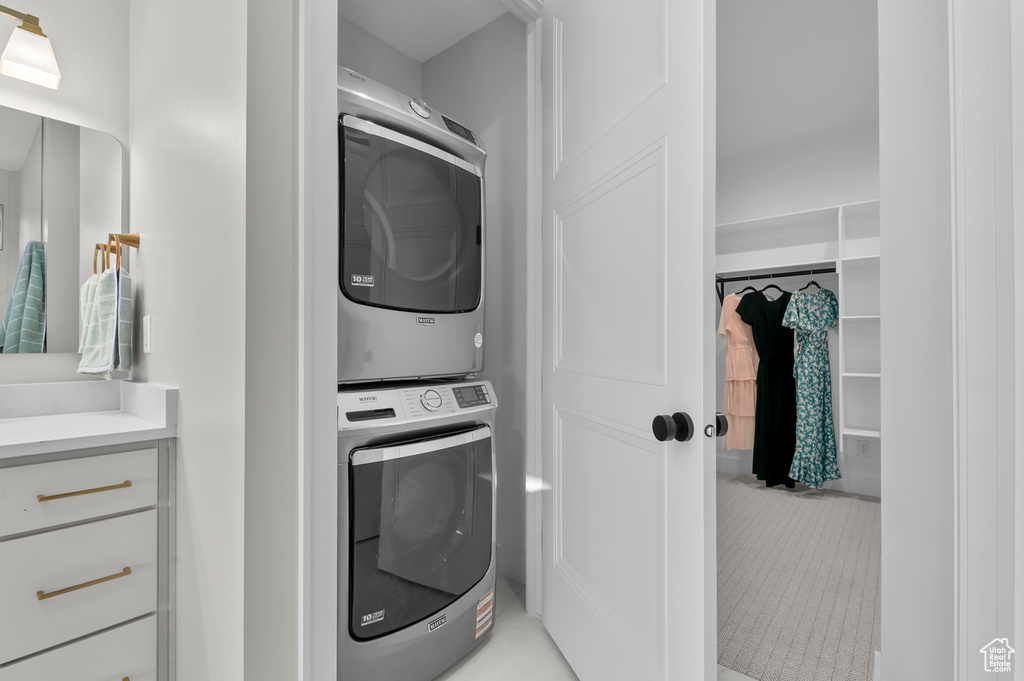 Laundry room featuring stacked washer / dryer and light tile patterned floors