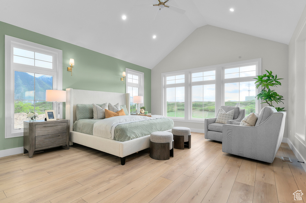 Bedroom with light wood finished floors, baseboards, multiple windows, recessed lighting, and high vaulted ceiling