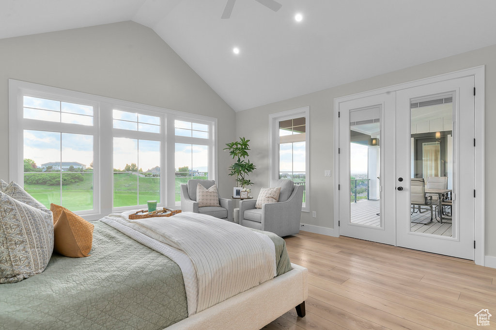Bedroom featuring french doors, high vaulted ceiling, access to outside, light wood-style floors, and recessed lighting