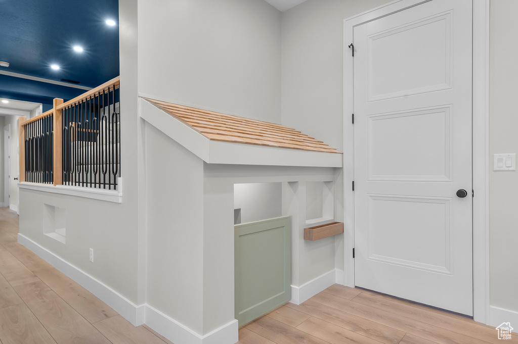 Hallway featuring wood-type flooring, baseboards, and recessed lighting