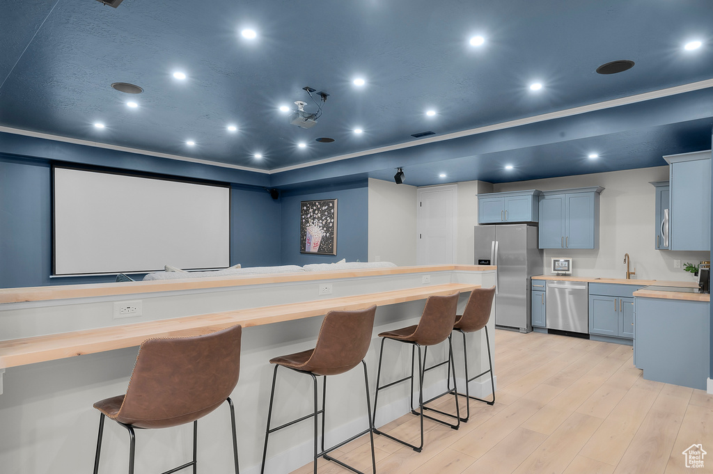 Cinema room featuring a sink, light wood-style flooring, and recessed lighting