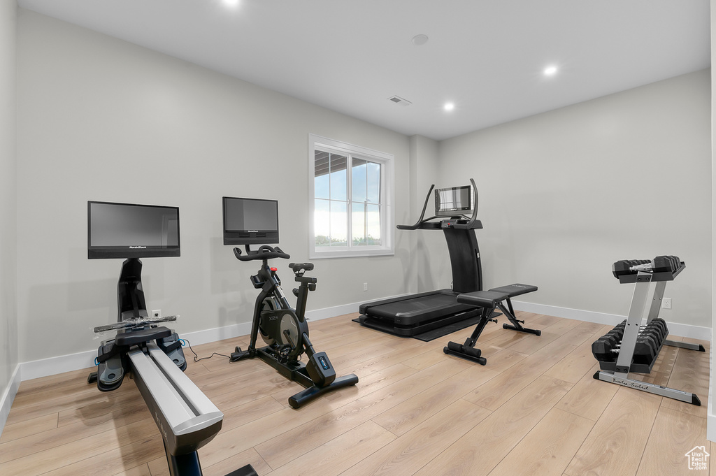 Exercise area featuring recessed lighting, light wood-style flooring, and baseboards