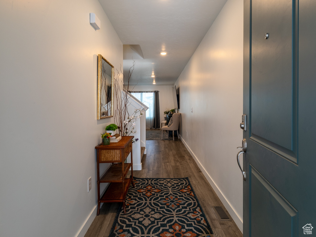 Hall with dark wood-style flooring, baseboards, and recessed lighting