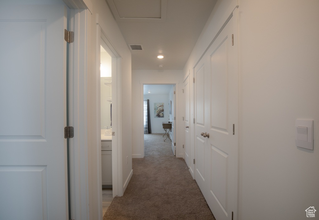 Corridor with light carpet and baseboards