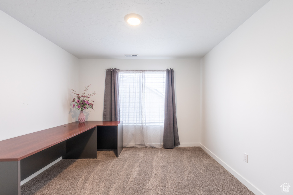 Unfurnished office featuring carpet flooring and baseboards