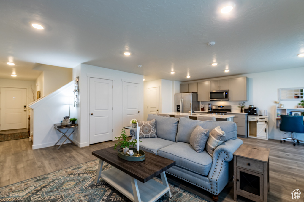 Living area with wood finished floors, recessed lighting, and baseboards