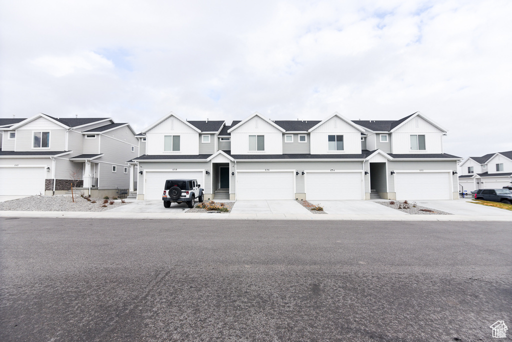 View of property with a residential view and an attached garage