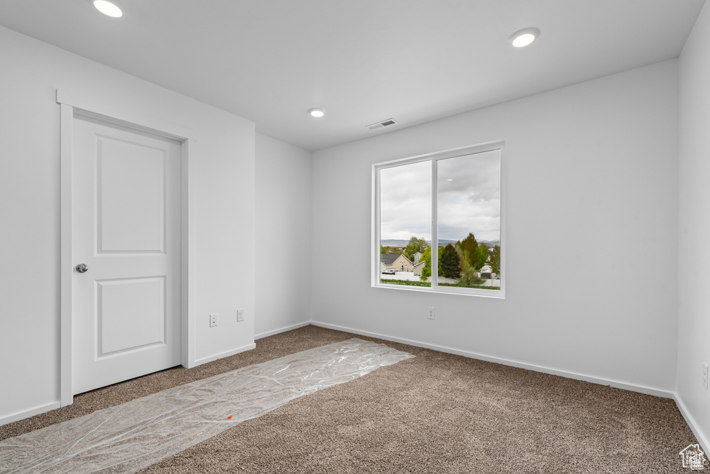 Carpeted empty room featuring recessed lighting and baseboards