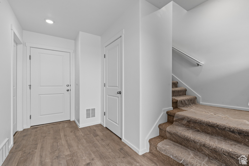 Entryway featuring wood finished floors, baseboards, stairs, and recessed lighting