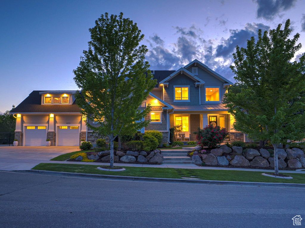 Craftsman-style house featuring concrete driveway and stone siding