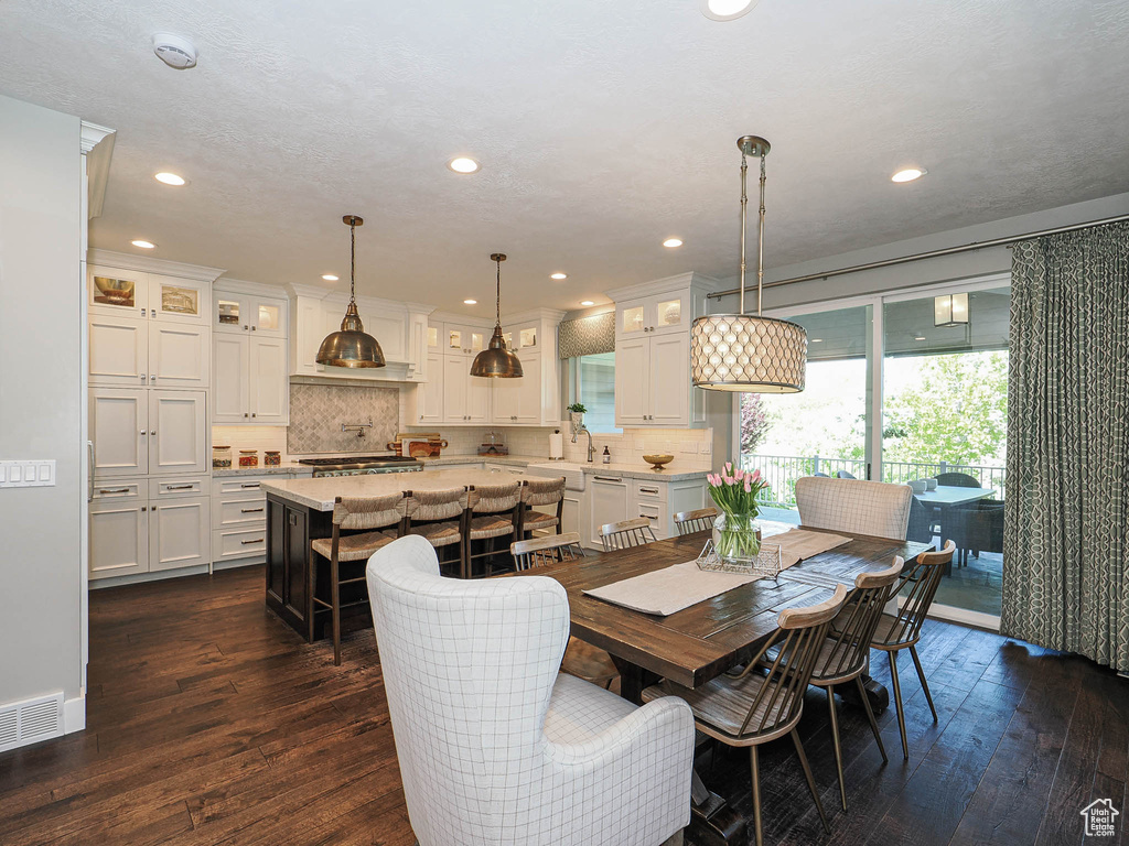 Dining area featuring dark wood-type flooring and recessed lighting