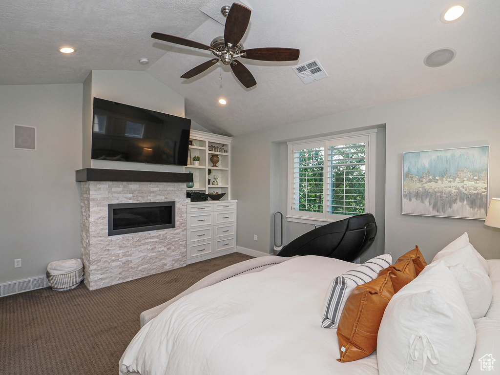 Bedroom featuring carpet floors, lofted ceiling, recessed lighting, a stone fireplace, and baseboards
